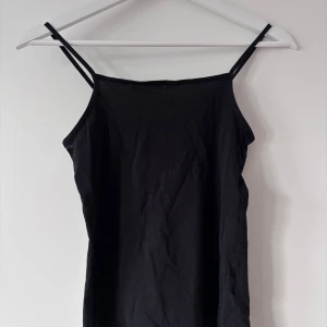 Svart linnetopp - Snygg svart linnetopp med smala axelband. Perfekt för en stilren och enkel look. Passar bra till både jeans och kjol. Storlek: EUR 146/152 men passar mig som vanligtvis bär storlek XS/S