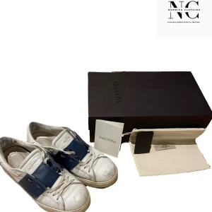 Valentino sneakers i vitt och blått - Säljer ett par stilrena Valentino sneakers i vitt med en bred blå rem över ovansidan. Skorna har en klassisk design med rund tå och är tillverkade i skinn. Perfekta för en trendig look. Kvitto ingår Cond:8/10 storlek 41 passar även 42. Kan tänkas gå ner i pris vid snabb affär.// Nordica Clothing.