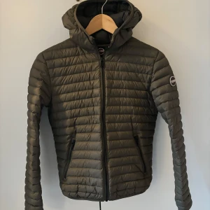 Jacka från Colmar  - Säljer en olivgrön/khakifärgad tunn dunjacka från Colmar perfekt för vår och höst. Mycket fint skick! Stl 154 (10-12 år).