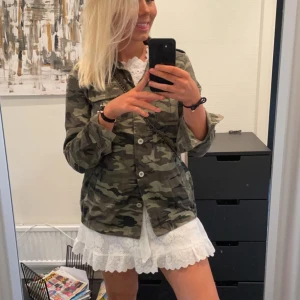 Camouflagejacka med knappar - Snygg och trendig camouflagejacka med knappar framtill. Jackan har en normal passform och långa ärmar.