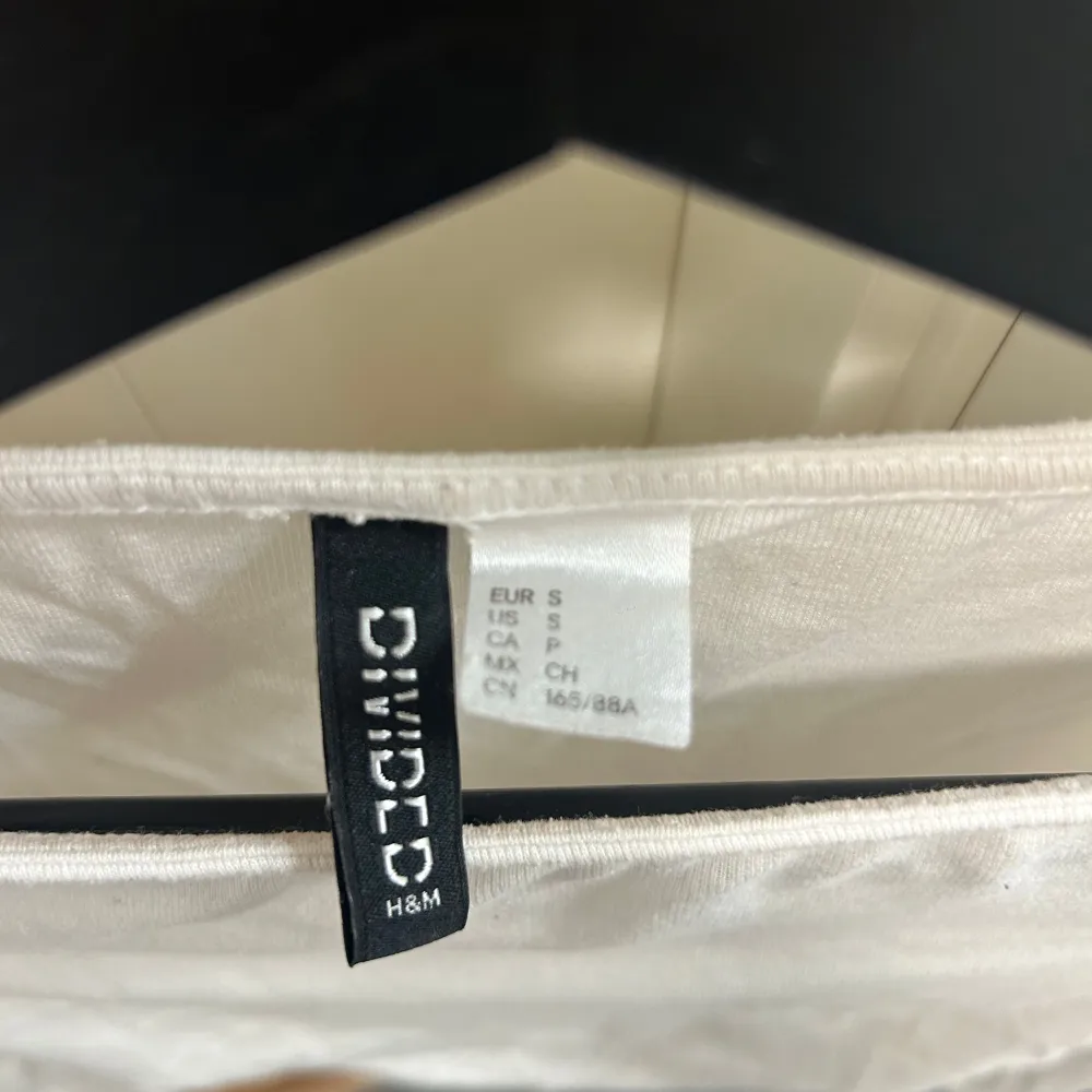 Säljer en stilren vit långärmad topp från H&M Divided. Toppen har en åtsittande passform och är tillverkad i ett mjukt material som ger en bekväm känsla. Perfekt för att matcha med jeans eller kjol. Hör av dig vid intresse!. Yläosat.