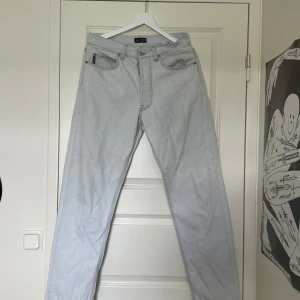 Armani Jeans - Snygga ljusblå jeans från Armani med klassisk femficksdesign och diskret logga på bakfickan. Perfekta för en stilren look. De har en rak passform och är tillverkade i ett bekvämt denimtyg.