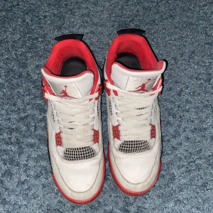 Nike Air Jordans fire red - Snygga Nike Air Jordans i vitt med röda och svarta detaljer som jag inte använder längre och bara vill bli av med. De är ej ”autentiska” men väldigt hög kvalitativa, inga tecken på att de skulle gå sönder eller större defekter. Storlek 42 passar 41 och möjligtvis 43.