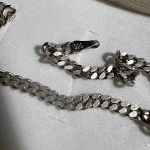 Silverarmband i kedjedesign - Snyggt silverarmband med klassisk kedjedesign. Armbandet har en stilren look och är perfekt för att komplettera din outfit. Tillverkat i 925 silver vilket ger en fin glans och hållbarhet.