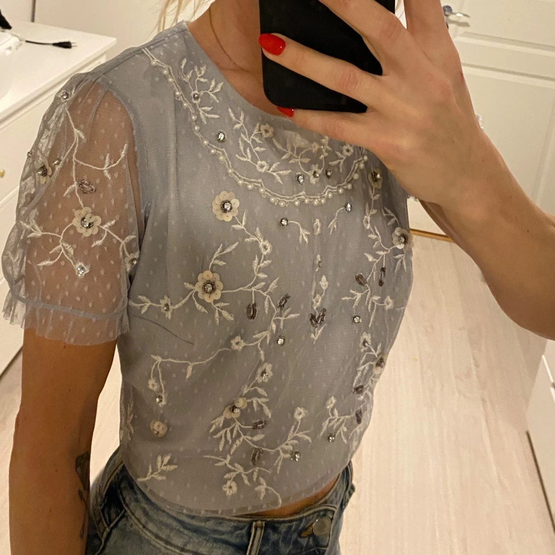 Ljusblå blus med broderade blommor - 1