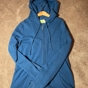 Blå hoodie från From Future - Säljer en snygg blå hoodie från From Future. Den har en dragkedja framtill och en praktisk huva med dragsko. Perfekt för en avslappnad stil.