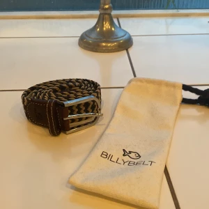 Flätat bälte från Billybelt - Säljer ett snyggt kvalitativt flätat bälte från Billybelt. Bältet har en silverfärgad spänne och detaljer i brunt skinn. Perfekt för att ge en stilren outfit. ‼️helt oanvänd‼️
