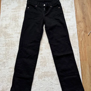 Svarta byxor från Dr. Denim - Snygga svarta byxor från Dr. Denim med klassisk design. De har en rak passform och är perfekta för en stilren look. Byxorna har fickor både fram och bak samt en knapp och dragkedja i midjan.