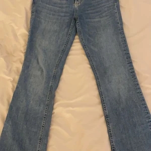 Blå jeans med bootcut - Snygga blå low waist jeans med bootcut-stil. Perfekta för vardags användning. Säljer pga att det inte kommer till användning och är i mycket bra skick med inga defekter. Längden är också rätt bra.