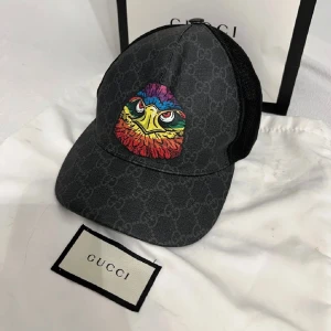 Svart keps från Gucci med färgglatt nu örnmotiv - Gucci keps som är i bra skick och inte så använd, påse finns och zipbag, storlek S, nypris 3200 men säljer den för 2700 för den är väldigt sällsynt, pris kan diskuteras vid snabbköp 