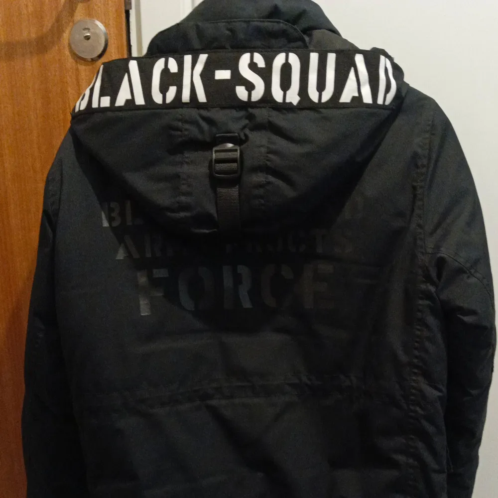 Säljer en svart jacka från Black Squad med coola detaljer som broderade märken och text på ryggen. Jackan har dragkedja och flera praktiska fickor. Perfekt för en urban look. Inga skador och använt ett par gånger. Passar också S. Takit.