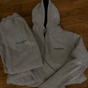 Grå hoodie från McKenzie - Säljer en stilren grå hoodie från McKenzie med dragkedja och justerbar huva. Perfekt för en avslappnad look. Den har långa ärmar och en mjuk insida för extra komfort.