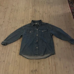 Oversized jeansskjorta  - Oversized jeansskjorta med tryckknappar i mellan blå tvätt