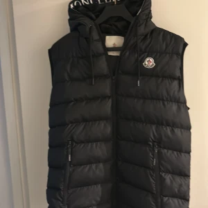 Moncler väst - Moncler väst. Är helt ny och inte använd. 10/10 skick, inga skador eller hål. Är storlek L men passar också M. Har ni frågor är det bara att fråga.