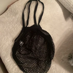 Svart strandväska  - Säljer en svart nätväska perfekt för shopping eller stranden. Den är lätt och rymlig med långa handtag för enkel bärning. Väskan är i mycket bra skick och passar perfekt för sommarens äventyr. 🖤