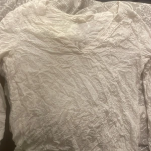 Vintage love blus  - Säljer en vit långärmad topp från H&M:s L.O.G.G.-kollektion. Den har en v-ringad design och är i ett lätt och bekvämt material. Perfekt för vår och sommar! Toppen är i bra skick men behöver strykas. Passar både till vardags och lite finare tillfällen.