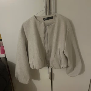 Beige jacka från Zara - Säljer en snygg beige jacka från Zara i storlek L. Jackan har en dragkedja framtill och långa ärmar. Perfekt för höst och vår med sin stilrena design. Ny med prislapp kvar, så den är i nytt skick. Passar både till vardags och lite finare tillfällen. 399kr kostar den på hemsidan och den är köpt i Spanien då prislappen står i Euro