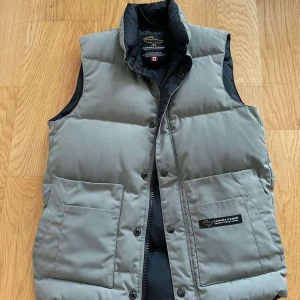 Grå dunväst från Canada Goose - Säljer en snygg och varm grå dunväst från Canada Goose. Bara å skriva vid funderingar eller mer bilder. 