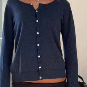 Mörkblå kofta med stjärndetalj - Säljer en snygg mörkblå kofta med vita knappar och en cool stjärndetalj på armbågen. Perfekt för höst och vår!