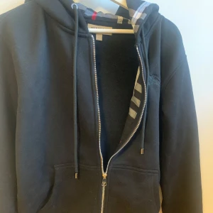 Burberry Zip Hoodie - Helt ny oanvänd Burberry tröja. Fick den i present och säljer den då den ej var i min storlek. Inga hål, defekter eller övrigt slitage. Den är äkta men har tyvärr ingen kvitto då det var en present!