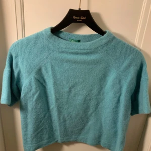Turkos stickad tröja i Kashmir - Säljer en superfin turkos stickad tröja i mycket bra skick. Den har en croppad stil och korta ärmar. Tröjan är mjuk och bekväm. I kashmir men tyvärr inte lapprn kvar. 