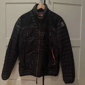 Svart Parajumper jacka - Säljer en snygg svart Parajumper jacka i nyskick. Jackan har en quiltad design med dragkedja och flera praktiska fickor. Perfekt för höst och vinter, håller dig varm och stilren. Passar både till vardags och lite finare tillfällen.