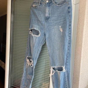 Blå jeans med slitningar från Missguided - Säljer ett par snygga blå jeans från Missguided i storlek EUR 38. Använda några gånger men är som nya😍 Högmidjade och snygga 