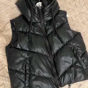 Svart skinn väst från Zara - Säljer en svart skinn väst från Zara i mycket bra skick. Västen har en dragkedja framtill och en hög krage med dragsko. Endast använt få tillfällen🤍