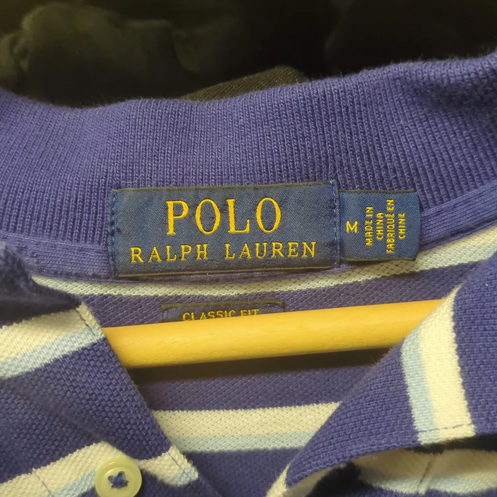 Säljer en klassisk blå och vit randig pikétröja från Ralph Lauren. Den har en broderad logga på bröstet och är i mycket bra skick. Perfekt för både vardag och festliga tillfällen. Passar bra till jeans eller chinos för en stilren look.. Tröjor & Koftor.