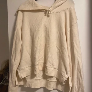 Beige hoodie med knyt - Mysig beige hoodie i mycket bra skick. Den har en avslappnad passform med långa ärmar och en knytning vid halsen. Perfekt för kyliga dagar när du vill vara både bekväm och stilren.