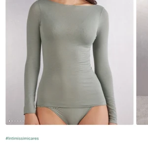 Grön långärmad topp från Intimissimi - Snygg och stilren grön långärmad topp från Intimissimi. Perfekt för både vardag och fest. Den är gjord i ett mjukt och stretchigt material som sitter bekvämt mot kroppen. Toppen har en enkel design utan mönster, vilket gör den lätt att matcha med olika outfits.