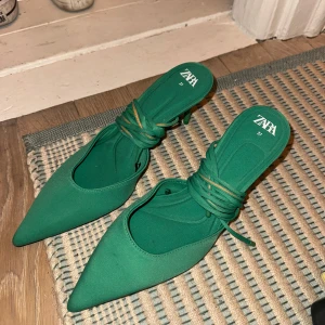 Gröna klackskor från Zara - Snygga gröna klackskor från Zara i storlek 37. De har en spetsig tå och knytning runt ankeln för extra stil. Perfekta för en festlig kväll eller en utekväll med vänner. Skorna är i mycket bra skick och snörena har gått upp lite men går nog att limma ihop eller liknande!