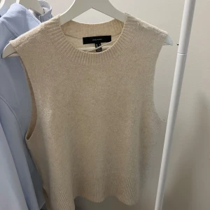 Beige stickad väst  - Säljer en superfin beige stickad väst från Veromoda. Perfekt för lager-på-lager under höst och vinter. Den har en ribbad kant vid ärmhålen och nederkanten, vilket ger en snygg och stilren look. Passar perfekt till både skjorta och t-shirt!