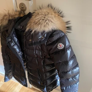 moncler jacka  - En jätte snygg äkta moncler jacka med päls, pälsen är avtagsbar.  jackan är i jätte fint skick finns inga märken eller något liknade på jackan, skriv privat för fler frågor, kvitto finns, du får med påsar osv, skriv privat för fler bilder. Varm,skön 