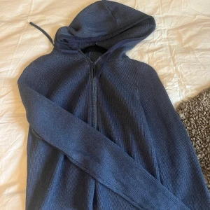 Mörkblå ribbad hoodie från Monki - Säljer en snygg mörkblå hoodie från Monki i ribbat material. Den har en dragkedja framtill och en mysig luva. Perfekt för ni i vinter. Passar både till vardags och chillkvällar. 🧢