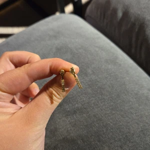 Guldörhängen med glittriga detaljer - Säljer ett par eleganta guldörhängen med glittriga detaljer. De har en stilren design med små gnistrande stenar som hänger ner. Perfekta för att ge en touch av glamour till vilken outfit som helst. Passar både till vardag och fest!