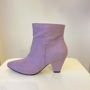 Ljuslila mocka boots med klack - Säljer ett par snygga ljuslila boots i mocka med spetsig tå och klack. De har en dragkedja på sidan för enkel på- och avtagning. Perfekta för både vardag och fest! 🥰helt nya!