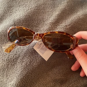 Brun och Guld Smala Solglasögon  - Super snygga solglasögon i guld och brun! (Första bilden visar färgen bäst). Small modell vilket ger dem vintage looken men de är aldrig använda!💕 Säljer även ett par likadana men i svart!