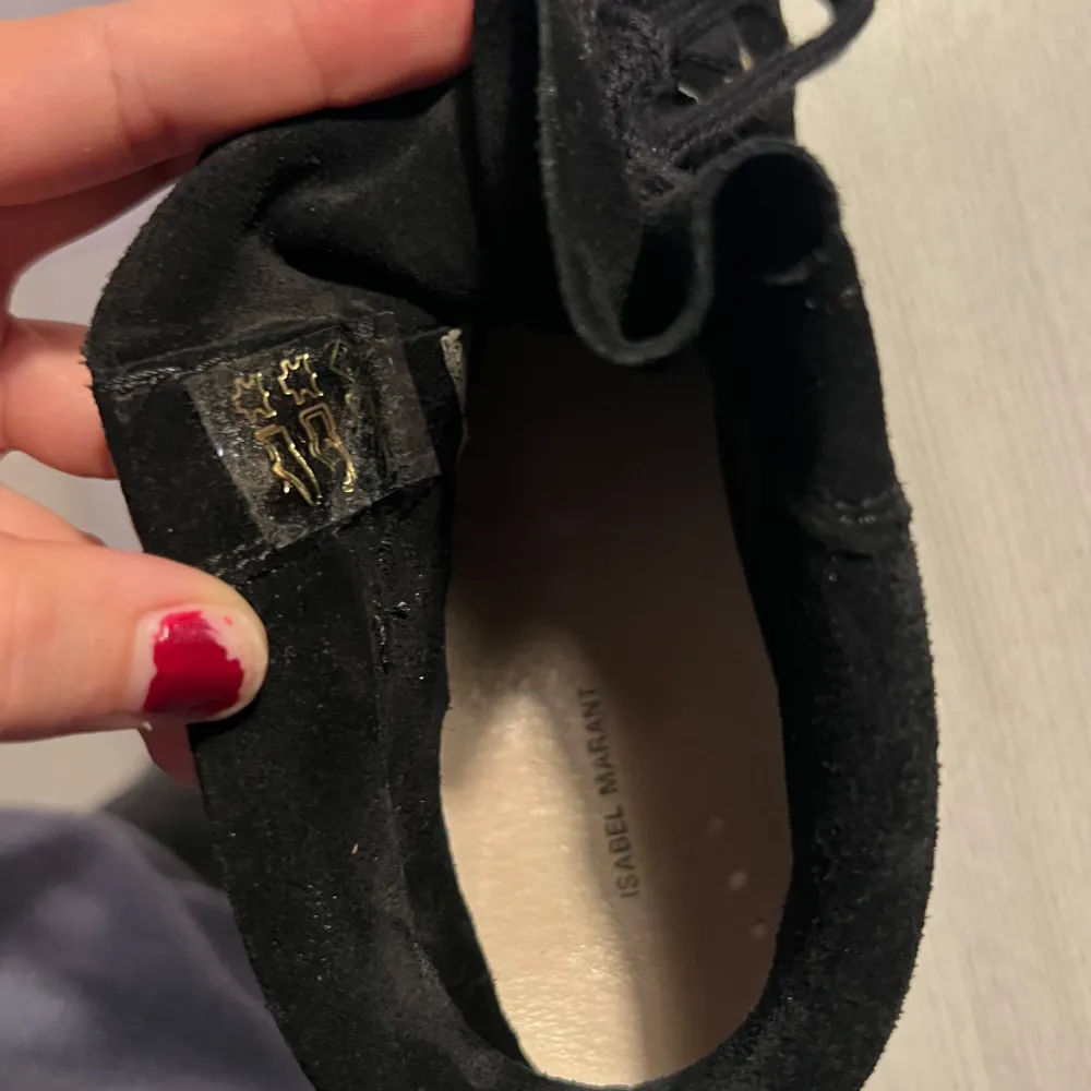 Säljer ett par svarta sneakers från Isabel Marant i mocka. De har en snygg kilklack och snörning framtill. Skorna är i mycket bra skick (endast använda ett fåtal gånger) och har en gummisula som ger bra grepp. Perfekta för både vardag och fest!. Skor.