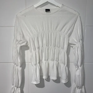 Vit långärmad blus från Gina Tricot - Säljer en superfin vit blus från Gina Tricot. Den har långa ärmar och ett snyggt rynkat mönster som ger en unik look. Säljer då den inte kommer till användning💖