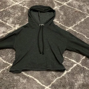 Mörkgrå hoodie från H&M - Säljer en mörkgrå hoodie från H&M. Den har en bekväm passform med långa ärmar och en justerbar huva med snören. Perfekt för en avslappnad stil. 🖤