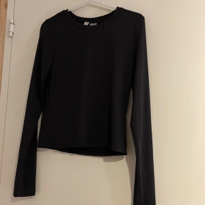 Svart långärmad topp från H&M Divided - Säljer en stilren svart långärmad topp från H&M Divided. Perfekt för en enkel och klassisk look. Toppen är i ett mjukt och bekvämt material som passar till många olika outfits.