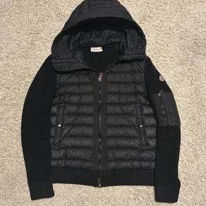 Svart moncler cardigan - Säljer en snygg cardigan från moncler med huva. Skicket är bra har använt den sparsamt. Priset kan diskuteras vid snabb affär. Vid minsta fråga hör av dig!