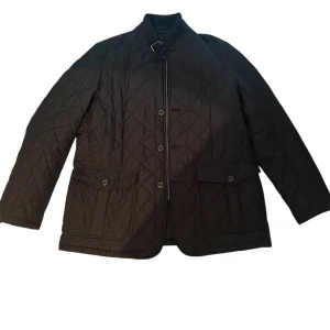 Svart quiltad jacka med dragkedja och knappar från barbour - Svart jacka från barbour. Storlek Xl