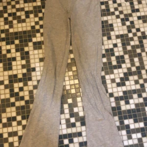 Grå mjukisbyxor - Säljer ett par bekväma grå mjukisbyxor med bootcut-stil. Perfekta för en avslappnad look. De är tillverkade i ett mjukt material som ger en skön känsla hela dagen.