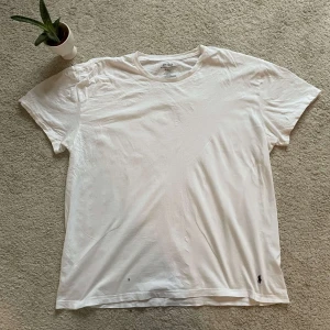 Vit t-shirt från Ralph Lauren - Säljer en klassisk vit t-shirt från Ralph Lauren i storlek XL. T-shirten är tillverkad i 100% bomull och har en liten broderad logga längst ner. Perfekt för en stilren och avslappnad look.