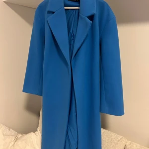 Lång blå kappa - Lång blå kappa från Gina. Köpt för 700kr men säljer för 170 då jag bara vill bli av med den. Använd 1-2 gånger