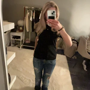 Svart stickad topp - Säljer en stilren svart stickad topp med korta ärmar. Perfekt för en minimalistisk look och kan enkelt matchas med olika outfits. Toppen har en klassisk design som passar till många tillfällen!💖