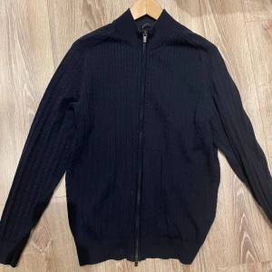 Svart tröja med dragkedja från Massimo Dutti - Snygg svart tröja från Massimo Dutti med dragkedja framtill. Fint skick utan skador. Marinblå färg i storlek large och sitter som en large. 