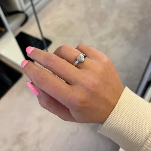 Silverring med hjärtformad detalj - Elegant silverring med en unik hjärtformad detalj på ovansidan. Perfekt för att ge en stilren touch till din look. Ringen har en slät yta och en modern design.